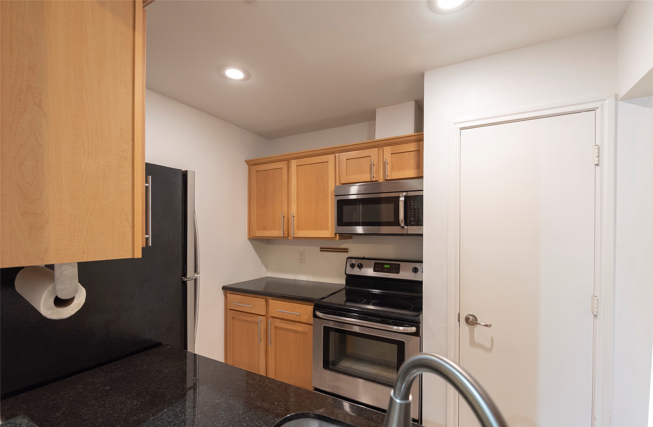 1100 Augusta Drive, Unit 76 Houston, TX 77057 - Photo 11 of 12 a kitchen with stainless steel appliances a refrigerator and a stove top oven