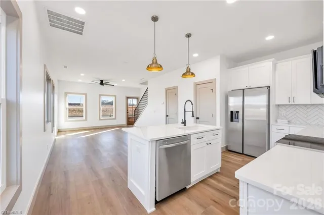 a kitchen with stainless steel appliances kitchen island granite countertop a stove and a refrigerator