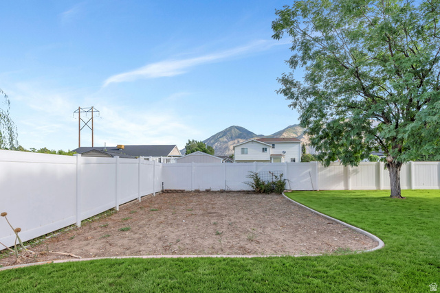 886 West 1700th Street North Mapleton, UT 84664 - Photo 20 of 21 Expansive backyard with a manicured lawn, white privacy fencing, and mature trees