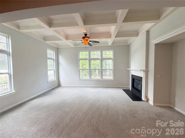 an empty room with windows and fireplace