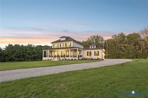 a view of a big house with a big yard and large trees