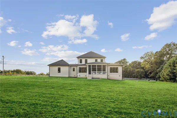a view of a house with a big yard and large trees