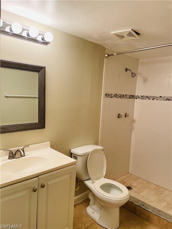 4290 Gulfstream Drive, Unit 9 Naples, FL 34112 - Photo 14 of 16 a bathroom with a sink mirror vanity and toilet