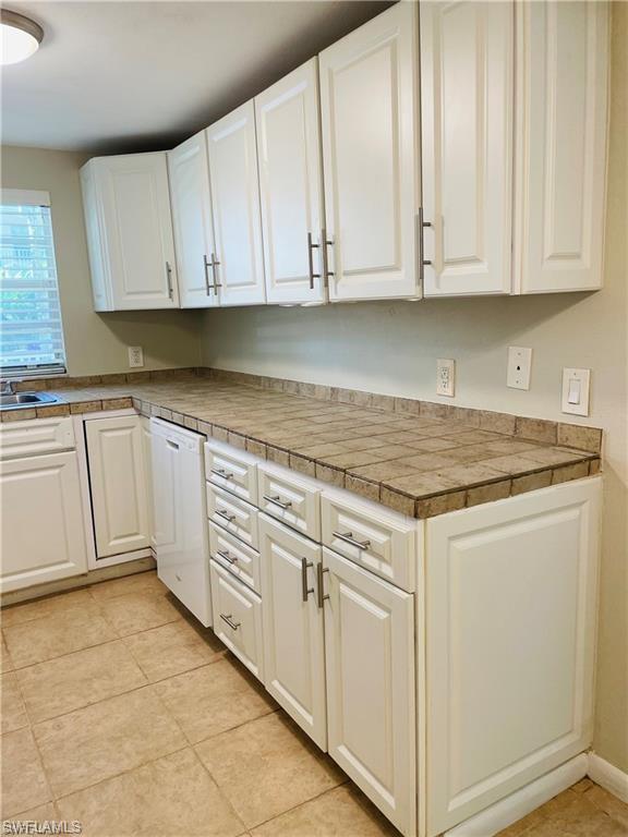 4290 Gulfstream Drive, Unit 9 Naples, FL 34112 - Photo 8 of 16 a kitchen with granite countertop white cabinets and sink