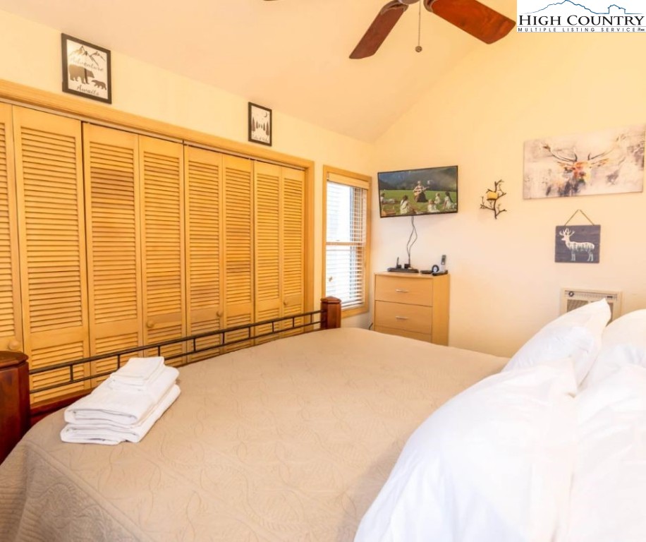 1534 Beech Mountain Parkway Beech Mountain, NC 28604 - Photo 13 of 29 a bedroom with a large bed and a chandelier