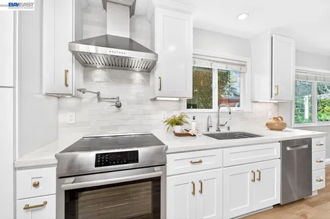 a kitchen with a stove and white cabinets
