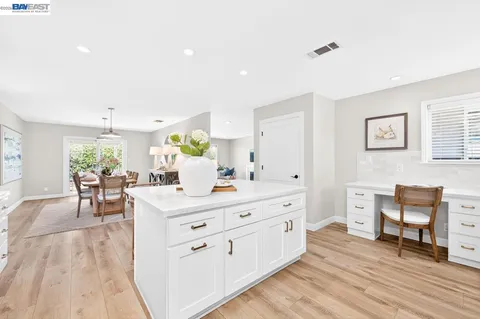 a living room with furniture and a dining table with wooden floor