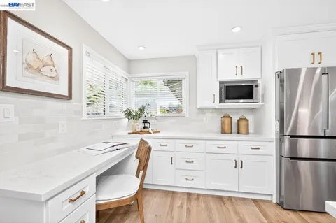 a kitchen with stainless steel appliances a refrigerator sink and white cabinets