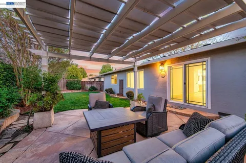 a view of a patio with couches table and chairs and potted plants
