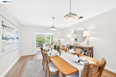 a view of a dining room with furniture a chandelier and wooden floor