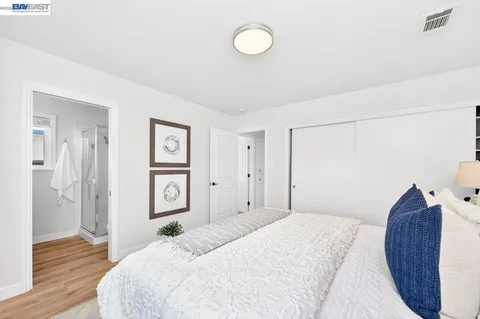 a bedroom with a bed and a painting on the wall