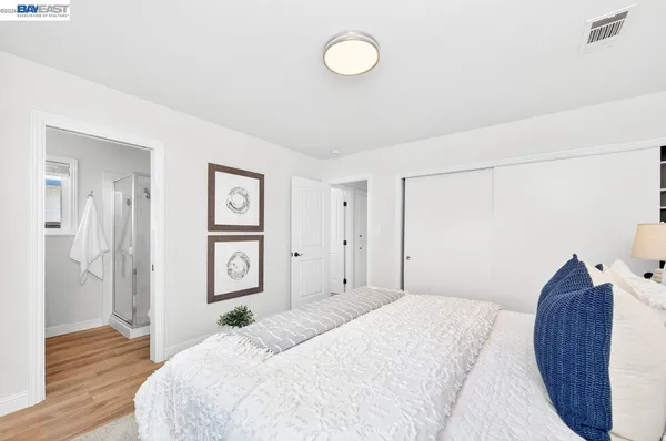 a bedroom with a bed and a painting on the wall