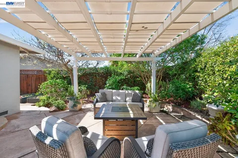 a view of a patio with couches table and chairs and potted plants
