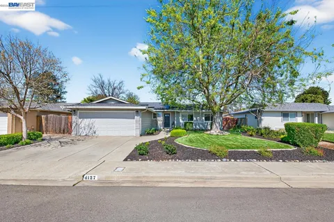 a front view of a house with a yard and outdoor seating