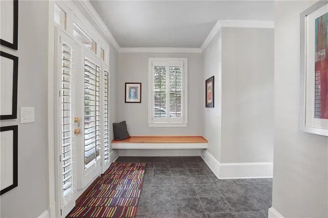 a room with chandelier fan and windows