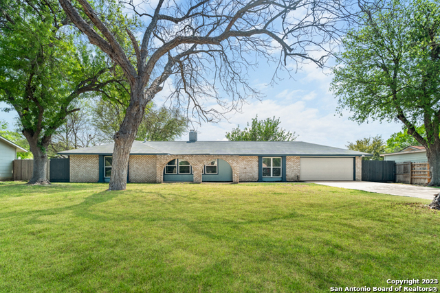 a view of a house with a yard and trees