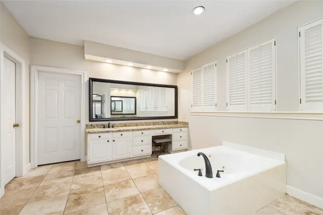 a bathroom with a tub a window and a shower