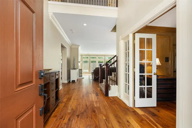 a view of a hallway with wooden floor and staircase