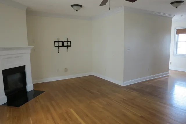 a view of a room with wooden floor and a fireplace