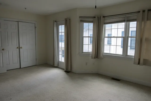 an empty room with windows and closet