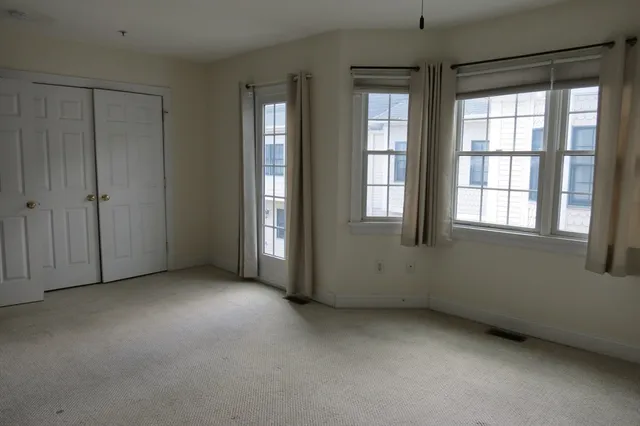 an empty room with windows and closet