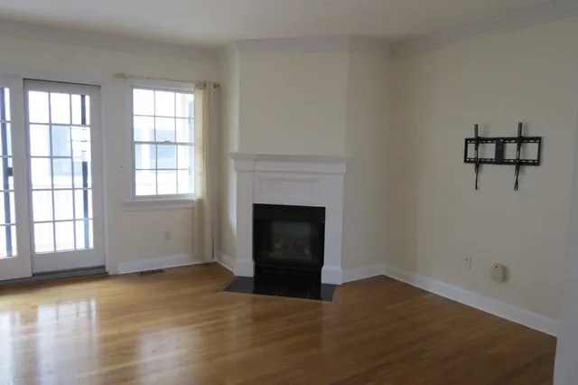 wooden floor fireplace and windows in an empty room