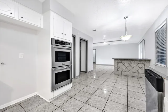 a kitchen with granite countertop a stove a microwave and a sink