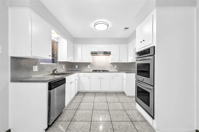 a kitchen with a sink a stove and cabinets