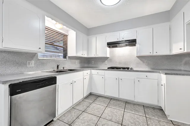 a kitchen with granite countertop white cabinets white appliances and a sink