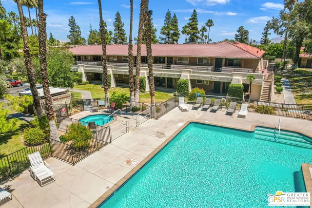 a view of swimming pool with outdoor seating and a garden