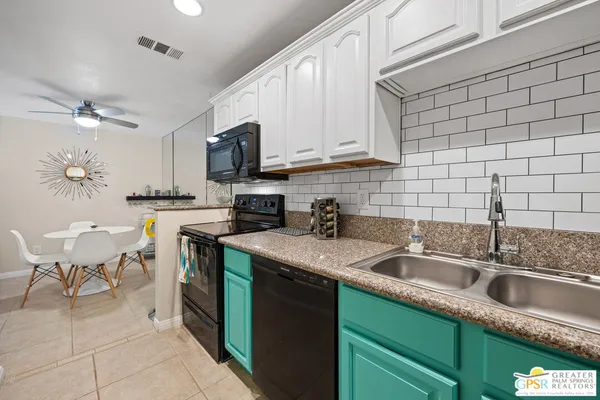 a kitchen with stainless steel appliances granite countertop a sink a stove counter space and cabinets