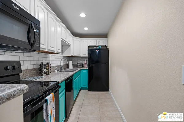 a kitchen with stainless steel appliances granite countertop a sink a stove and a refrigerator