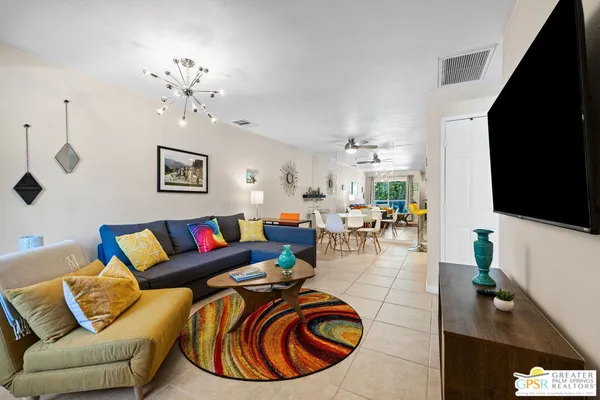 a living room with furniture a flat screen tv and a dining table