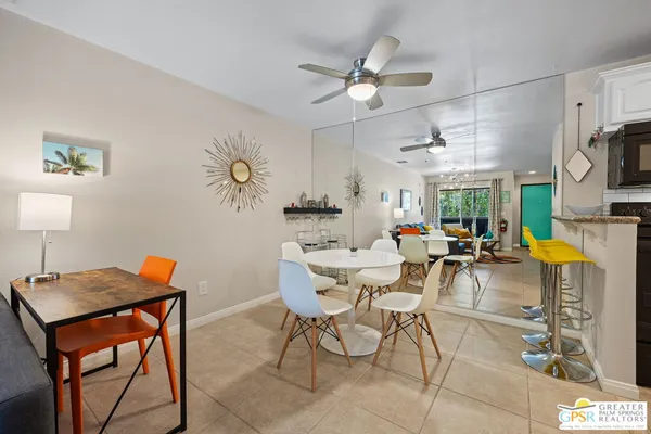 a living room with dining table and a chandelier