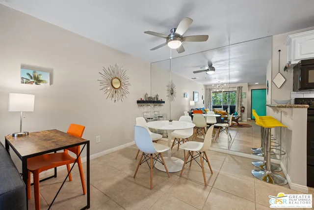 a living room with dining table and a chandelier