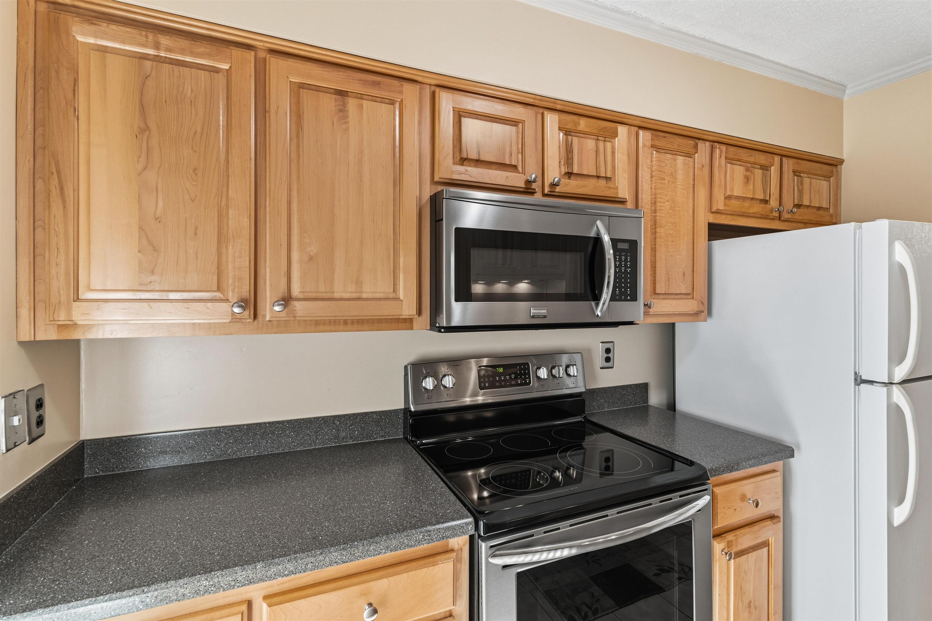 6905 Petworth Road, Unit 6905 Memphis, TN 38119 - Photo 15 of 32 a kitchen with granite countertop a stove and a microwave