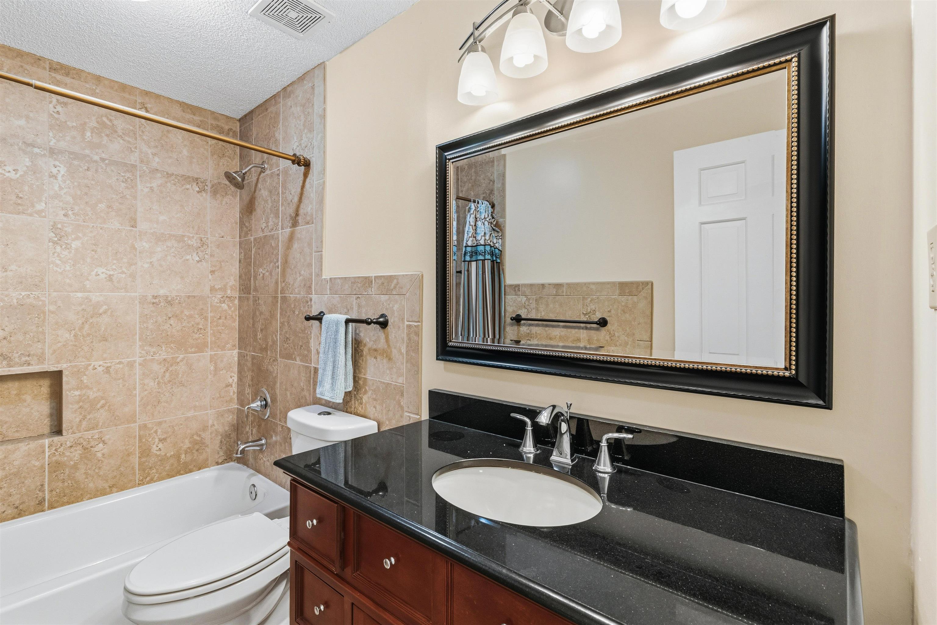 6905 Petworth Road, Unit 6905 Memphis, TN 38119 - Photo 28 of 32 a bathroom with a granite countertop sink toilet a mirror and shower