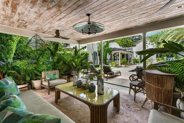 a living room with patio furniture and a potted plants