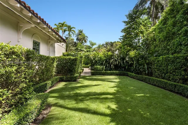 a front view of a house with a yard and fountain in middle