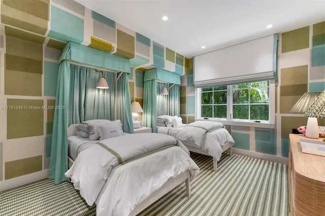 a bedroom with two beds and a large window