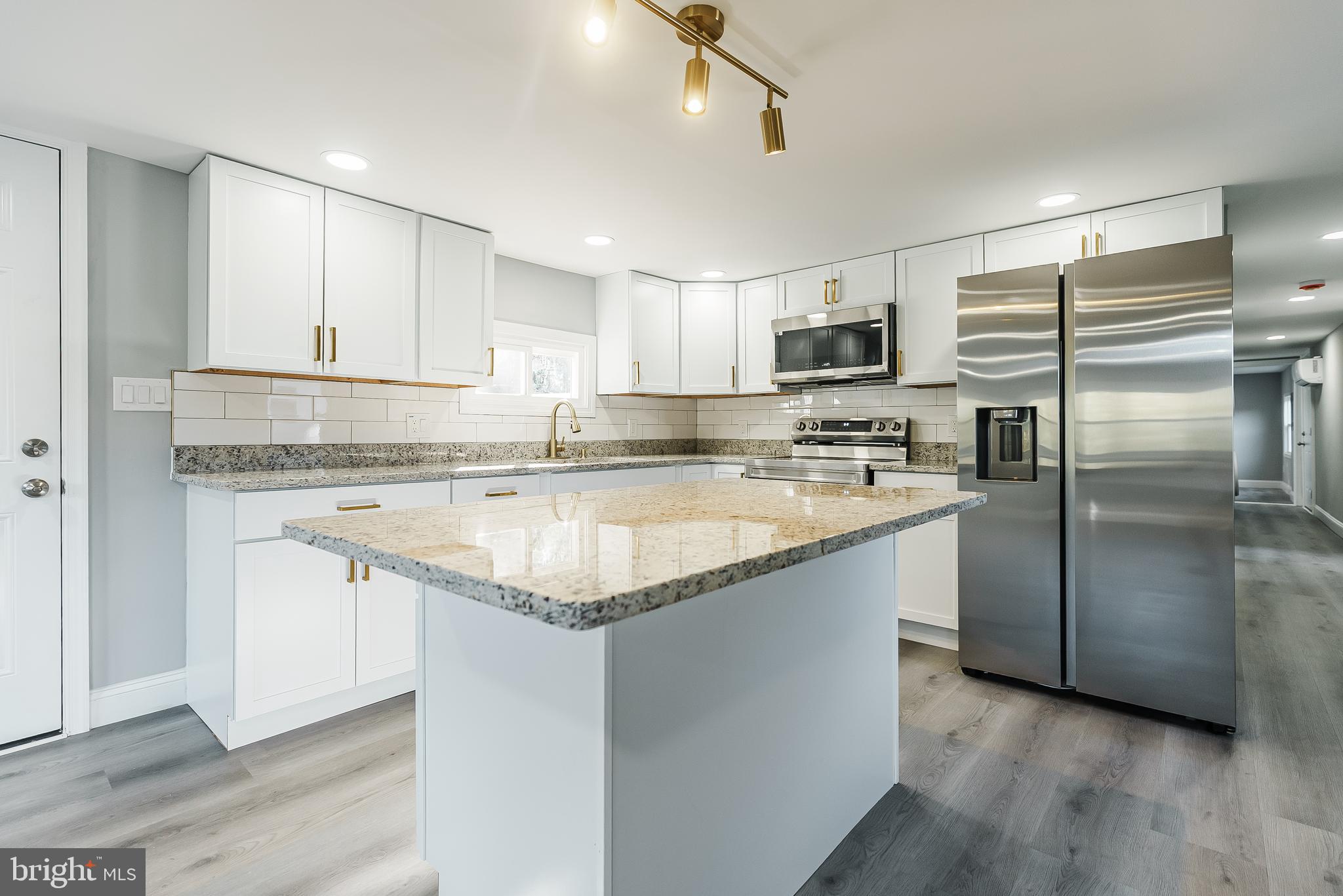 a kitchen with stainless steel appliances granite countertop a refrigerator and a stove top oven