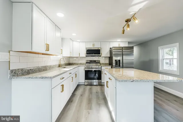 a kitchen with granite countertop a sink stove and refrigerator
