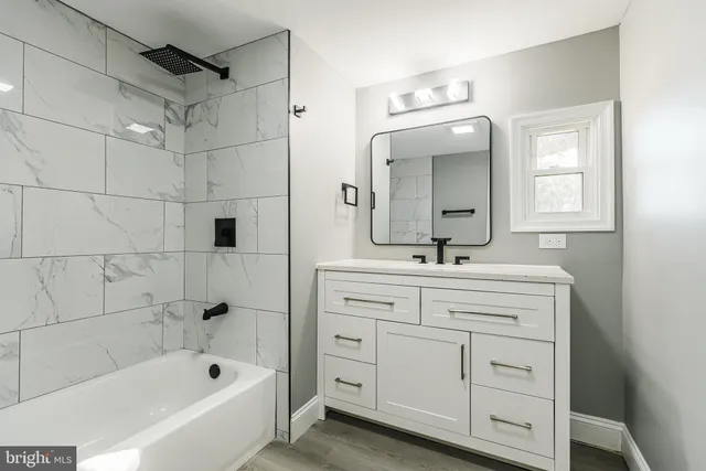 a bathroom with a double vanity sink mirror and bathtub