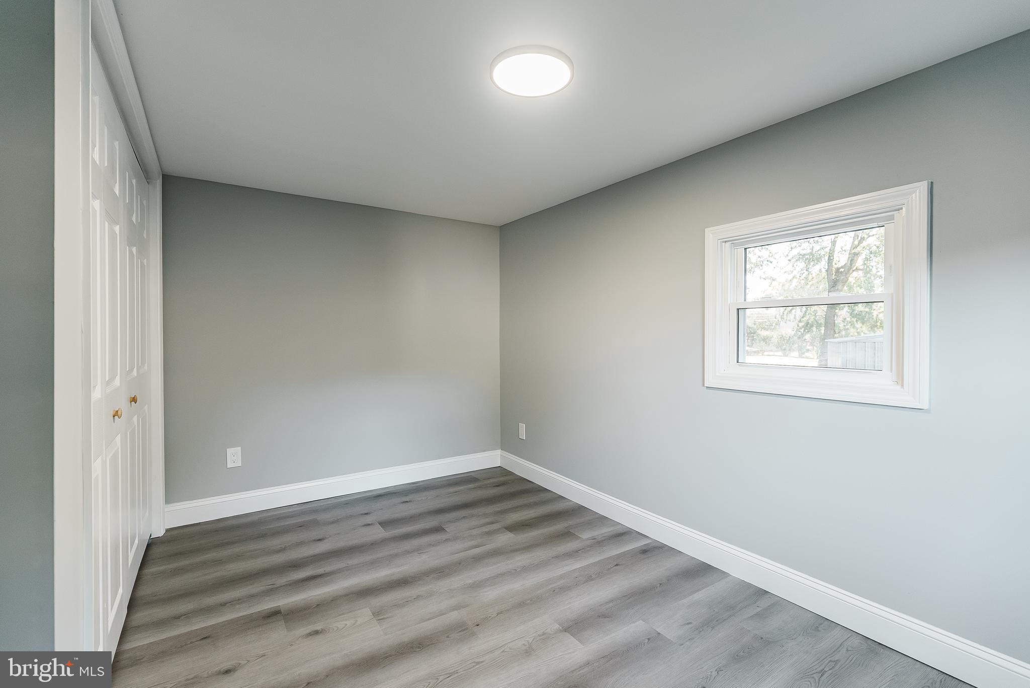115 5th Street, Unit 31 Delaware City, DE 19706 - Photo 8 of 11 an empty room with wooden floor and windows