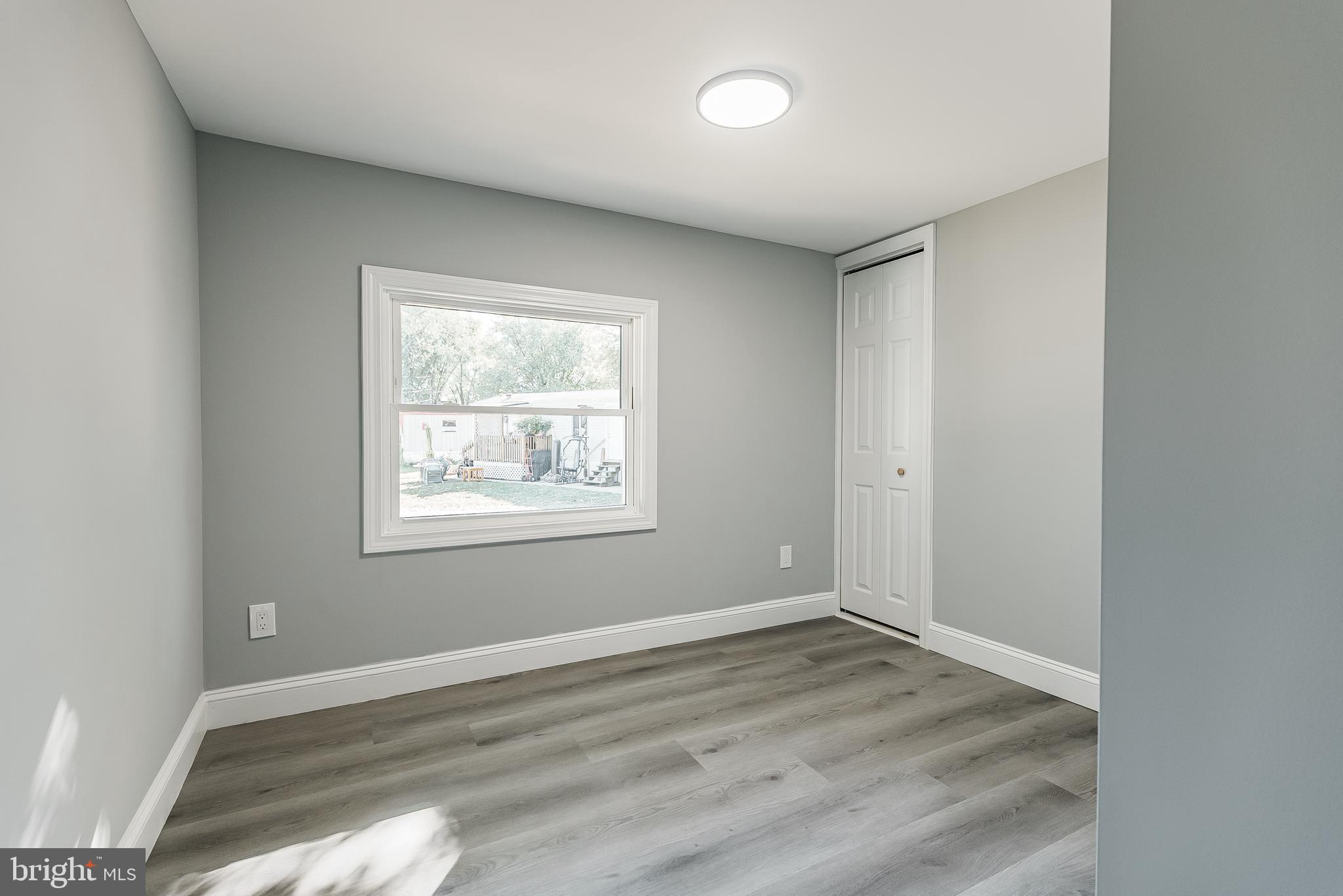 115 5th Street, Unit 31 Delaware City, DE 19706 - Photo 10 of 11 an empty room with wooden floor and windows