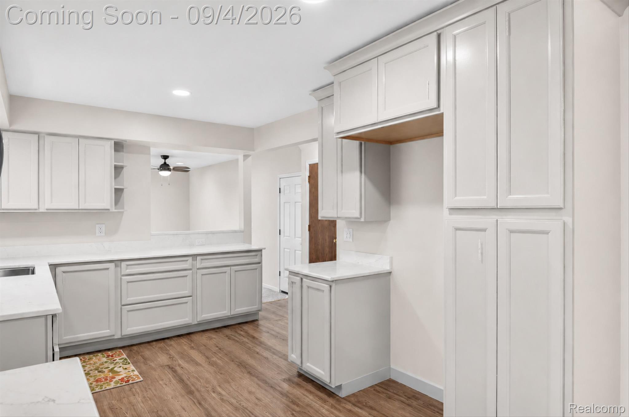 43182 Applewood Road Canton, MI 48188 - Photo 7 of 36 Kitchen featuring extensive light-toned cabinetry, solid surface countertops, wood-finish flooring, and recessed lighting