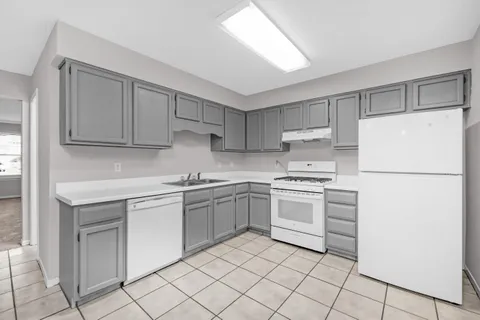 a kitchen with white cabinets and white appliances