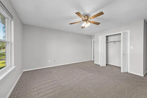 an empty room with chandelier fan