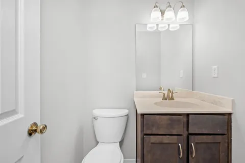 a bathroom with a granite countertop sink a toilet and shower