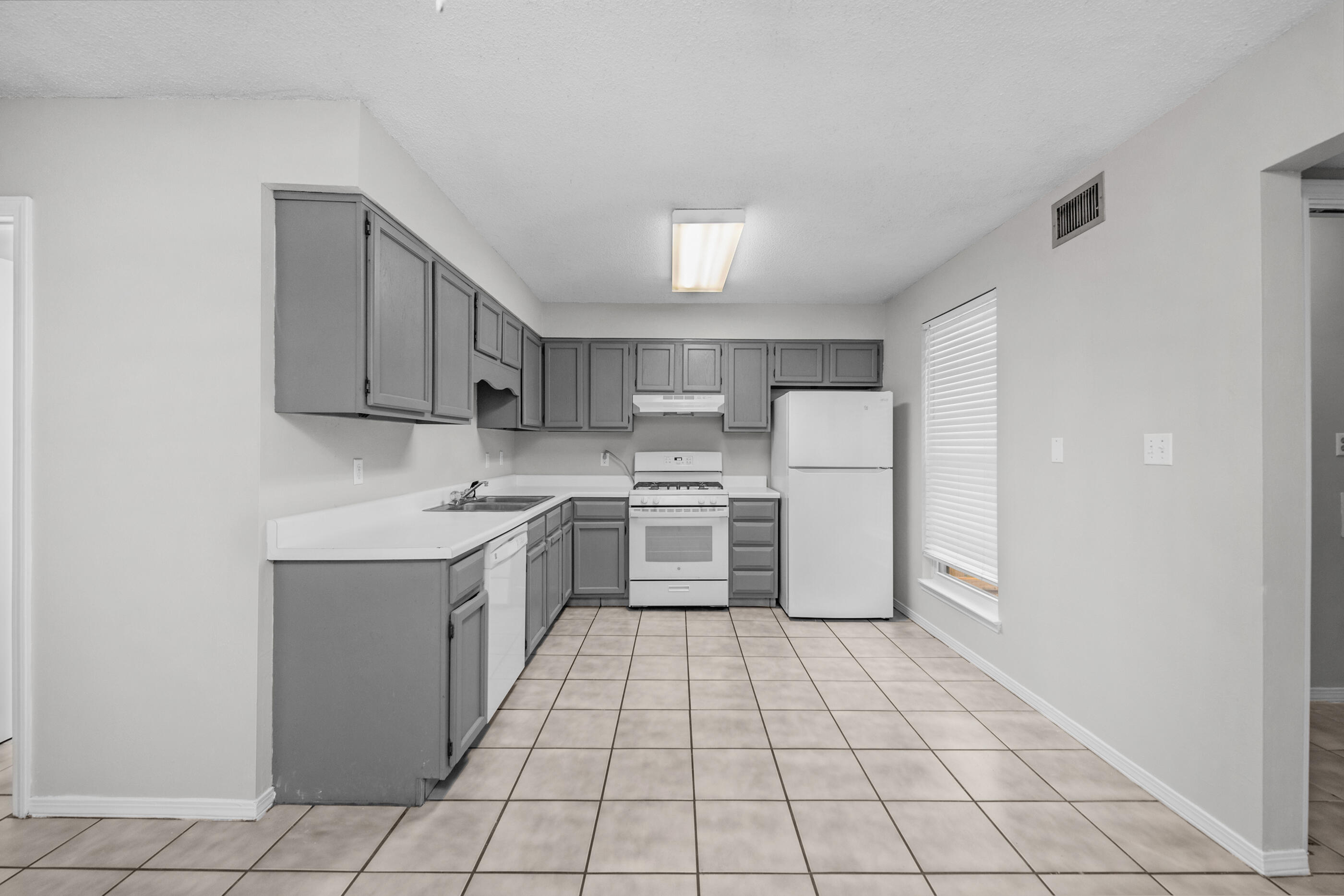 106 4th Avenue Shalimar, FL 32579 - Photo 2 of 29 a kitchen with stainless steel appliances a refrigerator sink and cabinets